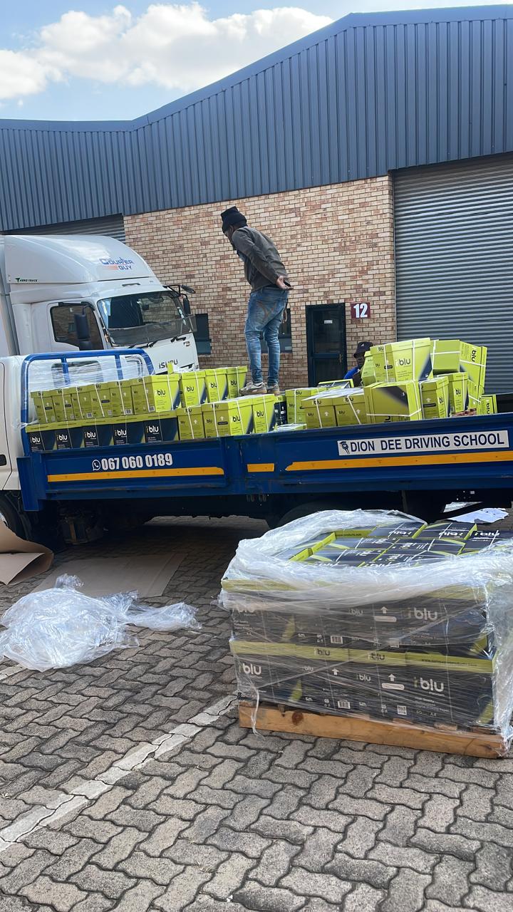 Palletised boxed supplies prepared beside a delivery truck